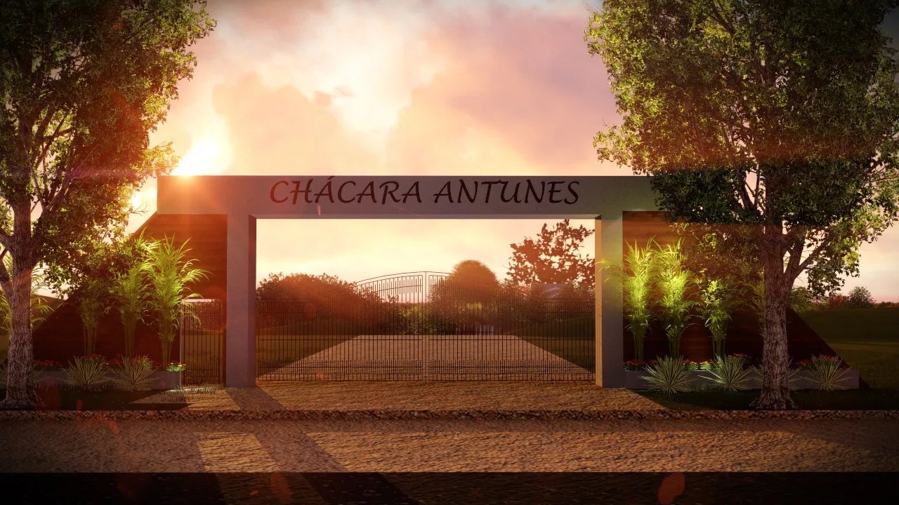 Portal de entrada emoldurado por árvores ao pôr do sol, com letreiro do nome da chácara e portão de ferro ao fundo