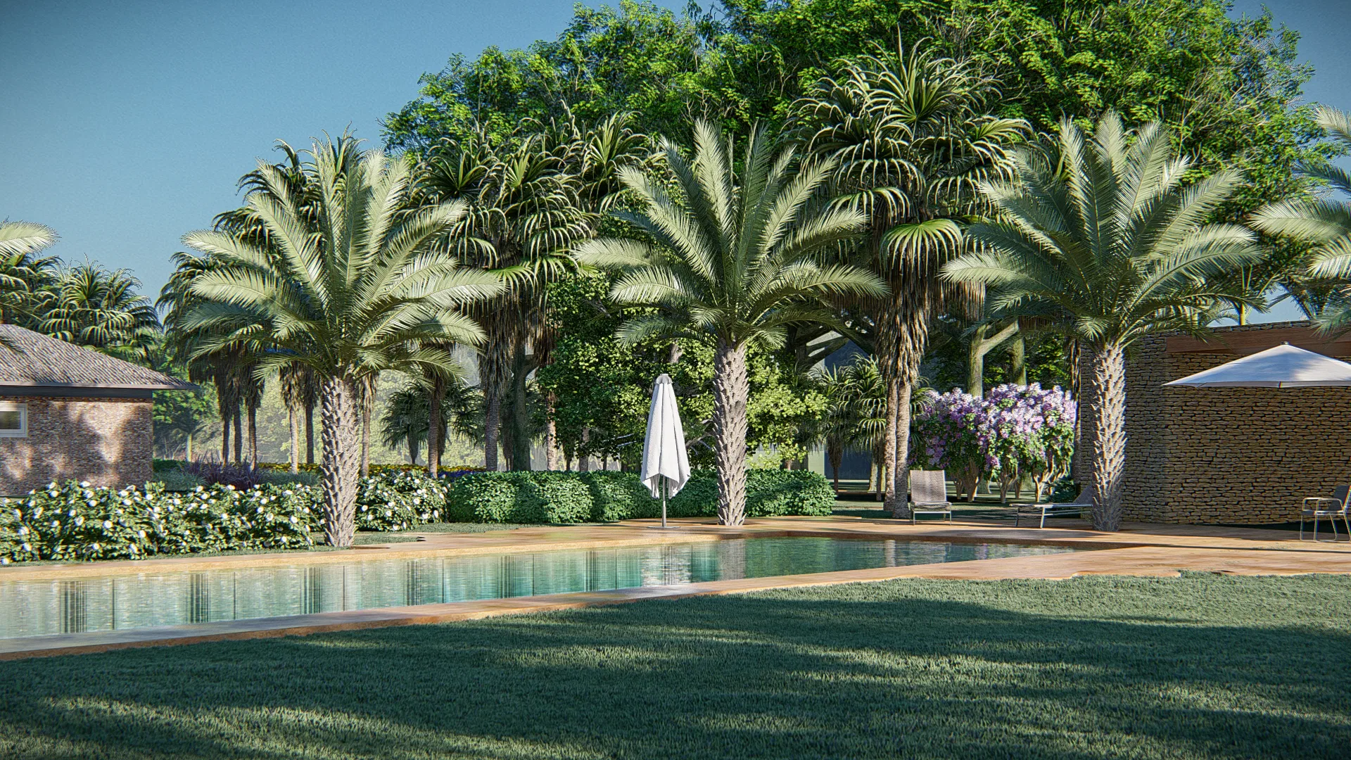 Piscina alongada ladeada por palmeiras imperiais, com casa de pedra à esquerda, guarda-sol aberto e arbustos floridos roxos à direita