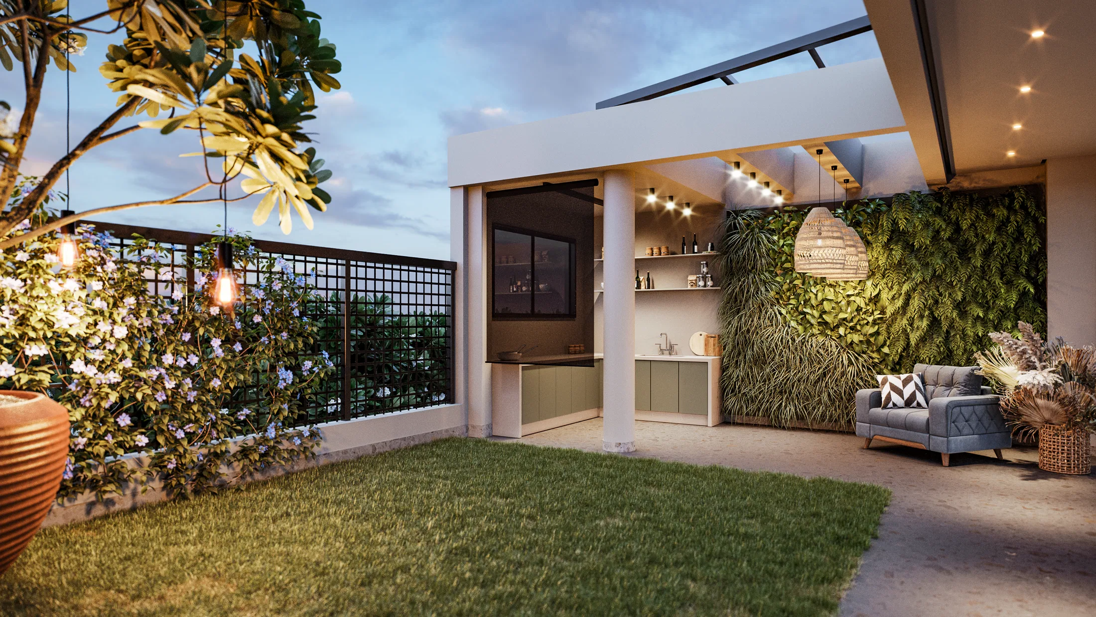 Terraço ao entardecer com gramado, fios de luz sobre arbusto florido, espaço gourmet de armários verdes e jardim vertical ao fundo.