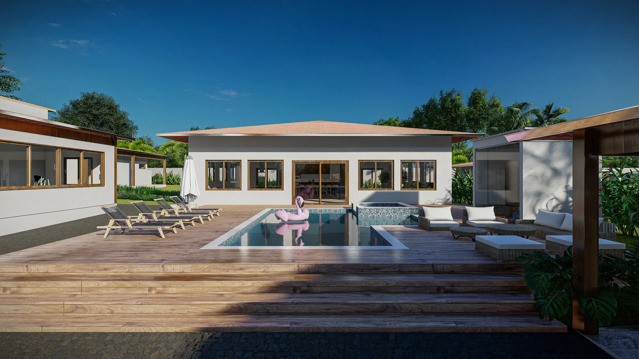 Piscina com deck de madeira diante de uma casa térrea de telhado inclinado, com espreguiçadeiras, boia de flamingo e pergolado com sofá.
