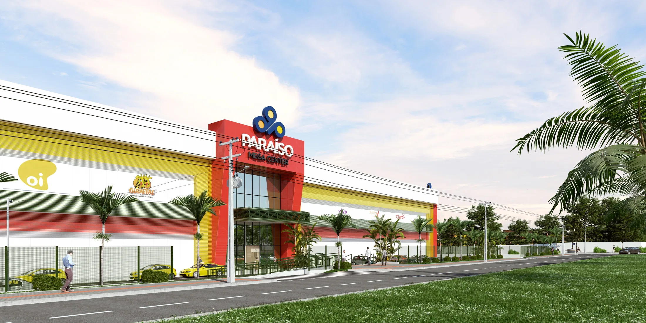 Fachada de um shopping center com revestimento vermelho e amarelo e torre de acesso sinalizada, palmeiras, faixa ajardinada e carros estacionados na via