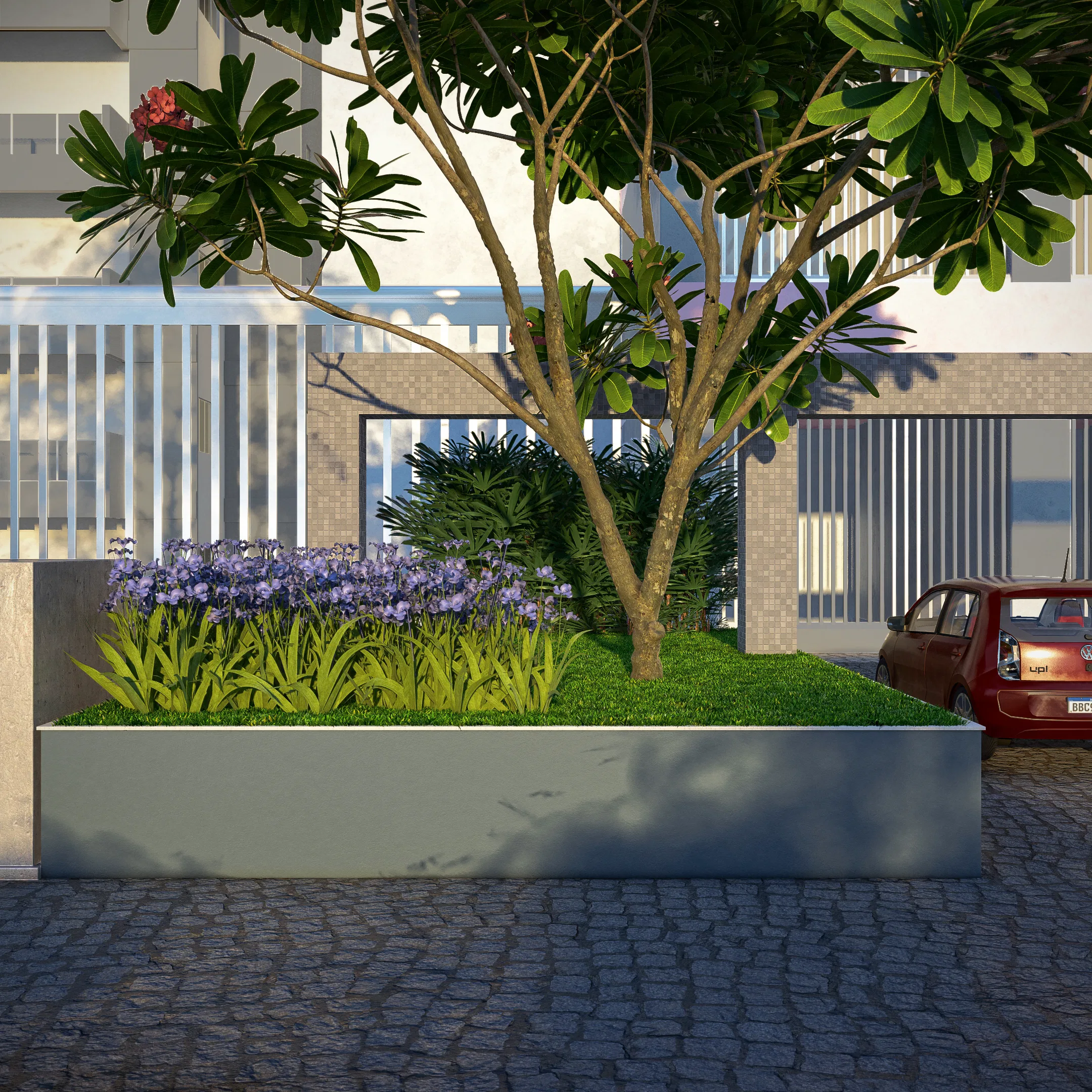 Jardineira elevada na entrada de um edifício, com frangipani, agapantos lilases e gramado, diante de um portão metálico e um carro vermelho estacionado.