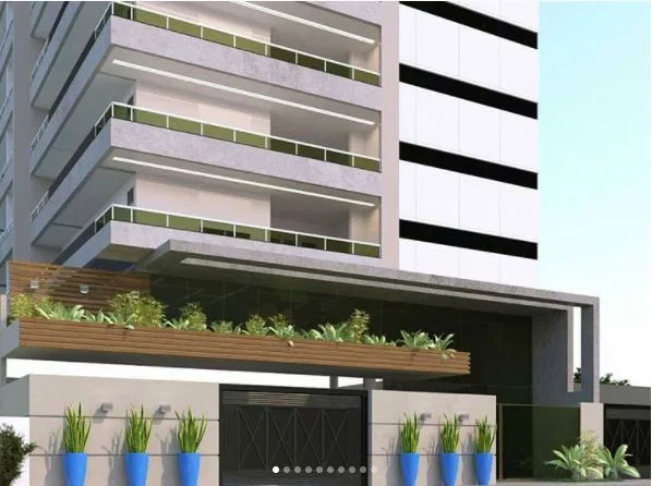 Fachada de edifício residencial com varandas moduladas em vidro, marquise de acesso e vasos azuis com plantas na entrada