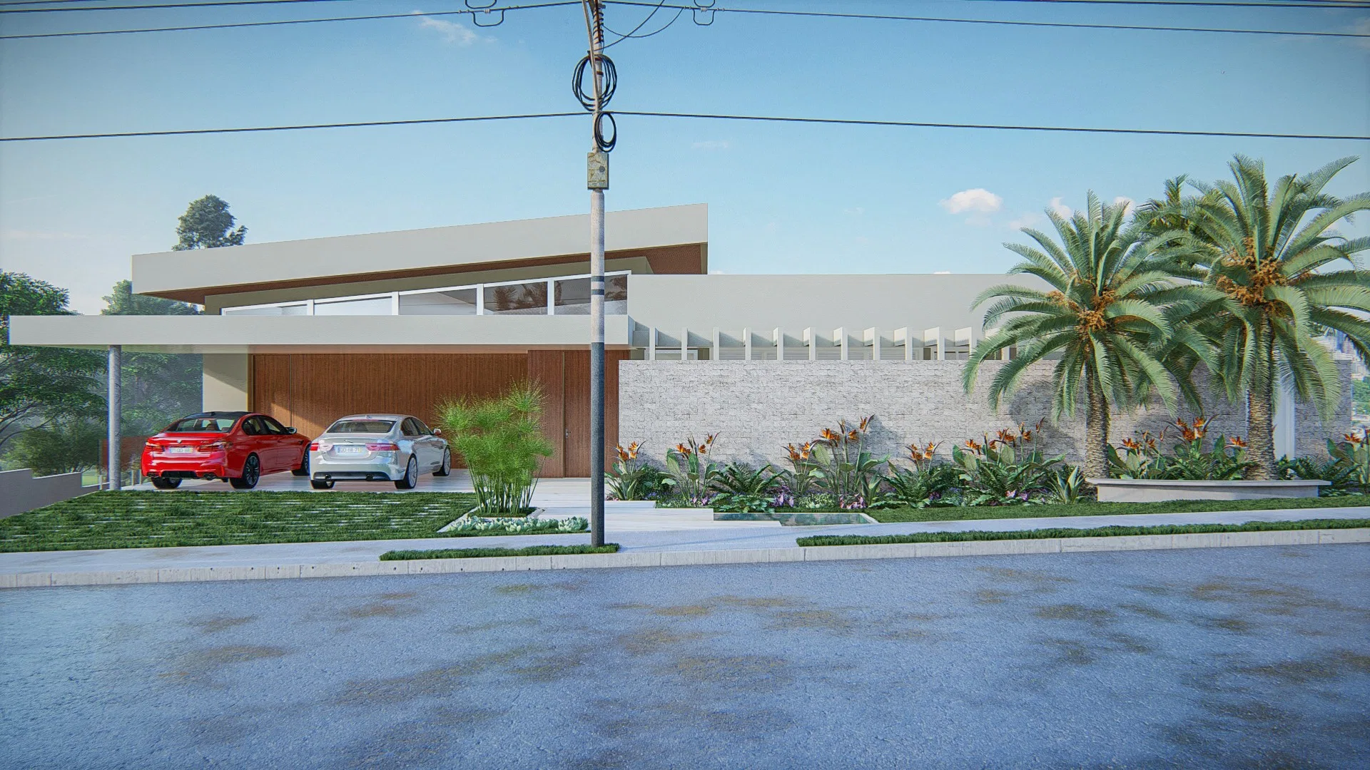 Fachada de residência com carro vermelho e carro branco sob marquise, muro de tijolo branco e canteiro florido ao longo do acesso, com palmeiras ao fundo